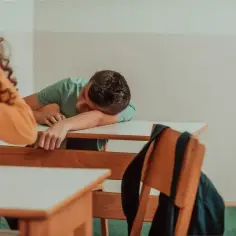 Uczeń śpi na ławce, zastanawiając się, czy uczeń nieklasyfikowany otrzymuje świadectwo.
