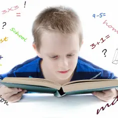 Chłopiec zmagający się z matematyką, otoczony symbolami i słowami jak "homework", "test", "calculation". Dysleksja a matematyka to wyzwanie.