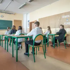 Uczniowie w klasie, przygotowujący się do egzaminu ósmoklasisty. Czy egzamin ósmoklasisty jest obowiązkowy? Tak, to ważny krok w edukacji.