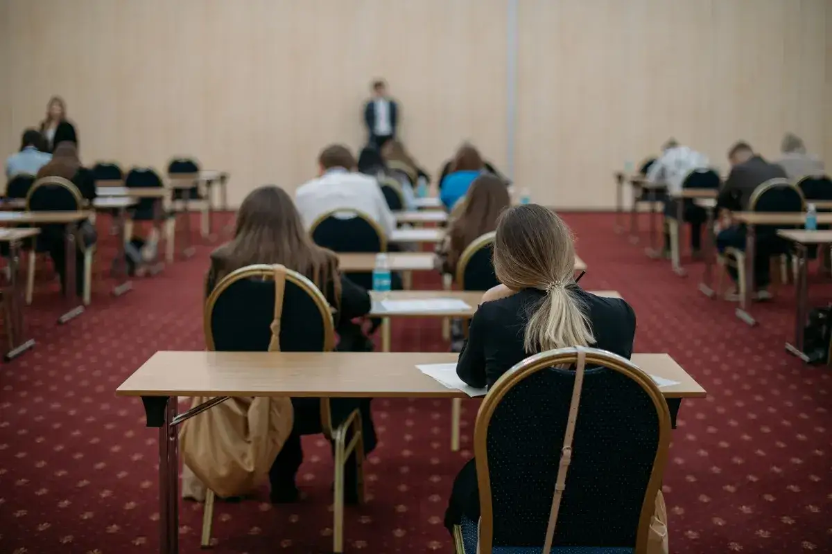 Uczniowie siedzą w rzędach, skupieni na zadaniach. To może być dzień, w którym piszą maturę poprawkową, mając nadzieję na lepszy wynik.