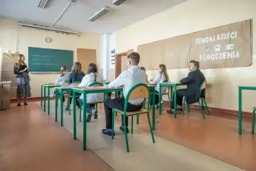 Uczniowie w klasie, przygotowujący się do egzaminu ósmoklasisty. Czy egzamin ósmoklasisty jest obowiązkowy? Tak, to ważny krok w edukacji.